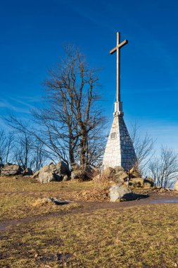 Sobotka, Polonya - 29 Ocak 2024: Tahta ve Stony Millennium Cross güneşli bir günde Sleza dağının tepesinde