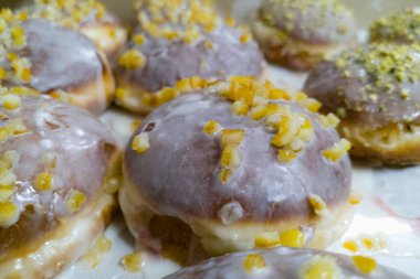 Fıstık kremalı ve ezilmiş fıstıklı ve turuncu çöreklerle dolu bir kutu.