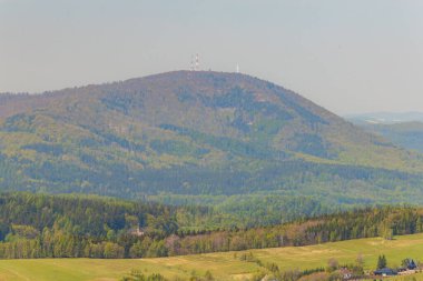 Walbrzych dağlarının güzel yeşil manzarası. Mavi gökyüzü Rogowiec dağının tepesinden görünüyor. Deniz seviyesinden 870 metre yukarıda. 