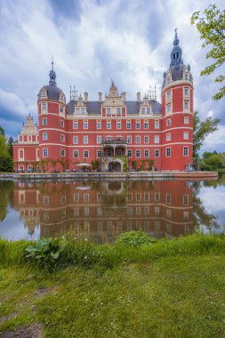 Bad Muskau, Almanya - 3 Mayıs 2024: Güzel ve görkemli Hermann von Puckler 'ın Şatosu Muskau Parkı' nın merkezinde, etrafında güzel yeşil açıklıklar ve küçük gölcüklere yansıyan