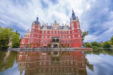 Bad Muskau, Almanya - 3 Mayıs 2024: Güzel ve görkemli Hermann von Puckler 'ın Şatosu Muskau Parkı' nın merkezinde, etrafında güzel yeşil açıklıklar ve küçük gölcüklere yansıyan