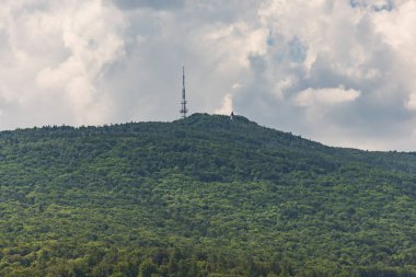 Sobotka, Polonya - 30 Mayıs 2024: Sleza Massif 'in yeşil ağaçlarla kaplı güzel manzarası Kutsal Bakire Meryem' in Ziyareti kilisesi ve radyo ve televizyon yayın merkezi kulesi