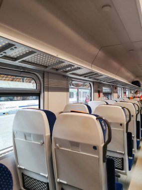 Varşova, Polonya - 12 Haziran 2024: Konforlu koltukları ve pencerelerden İstasyon Manzarası olan Modern Tren Otomobili