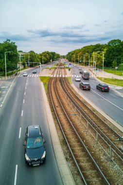 Varşova, Polonya - 14 Haziran 2024: Tramvay Demiryolları, Arabalar ve Yeşil ve Modern Altyapı ile çevrili yaya kaldırımlarıyla dolu şehir kavşağı