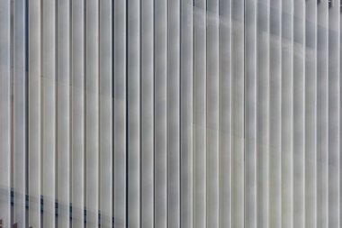 Dikey Metalik Çizgiler ve Cam Cephe Deseniyle Modern İnşaat Dış Görünümü