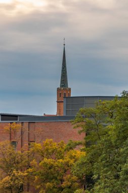 Wroclaw, Polonya - 26 Temmuz 2024: Gotik Kilisesi Wroclaw, Polonya 'da Modern Binaların Üzerinde Yükseliş ve Sonbahar Ağaçları - Tarihi ve Çağdaş Mimarinin Zıtlığı
