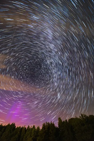 Karanlık gece gökyüzünde güzel yıldız izleri bazı tarlalar ve yüksek ağaçların siluetleri üzerinde Samanyolu ile hareket eden bulutlar ve uçan Perseidler