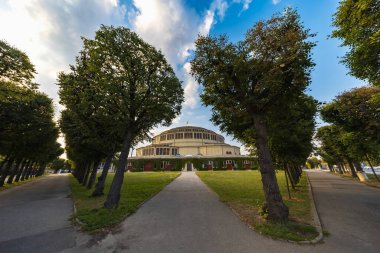 Wroclaw, Polonya - 12024 Ağustos: Wroclaw Centennial Hall Güneşli bir günde ağaçlarla kaplı bir yolun sonunda