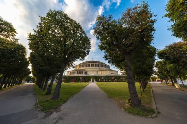 Wroclaw, Polonya - 12024 Ağustos: Wroclaw Centennial Hall Güneşli bir günde ağaçlarla kaplı bir yolun sonunda