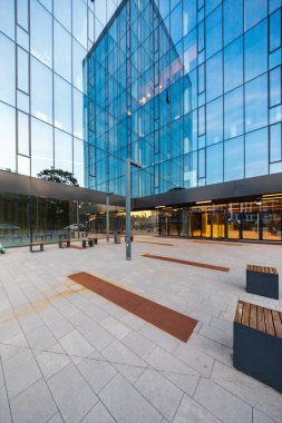 Wroclaw, Polonya - 7 Ağustos 2024: Cu Office binasının camsı görünümlü modern şirket mimarisi, gökyüzünü ve kentsel çevreyi yansıtıyor, çağdaş tasarımı sergiliyor