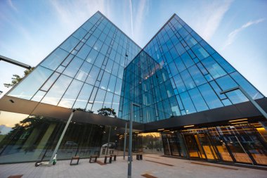 Wroclaw, Polonya - 7 Ağustos 2024: Cu Office binasının camsı görünümlü modern şirket mimarisi, gökyüzünü ve kentsel çevreyi yansıtıyor, çağdaş tasarımı sergiliyor