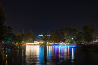Wroclaw, Polonya - 24 Ağustos 2024: Wroclaw 'daki Slodowa Adası' ndaki Odra Nehri boyunca canlı gece hayatı ve kentsel ambiyansı yansıtan renkli barlar