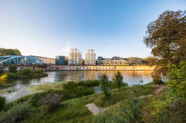 Wroclaw, Polonya - 30 Ağustos 2024: Wroclaw, Polonya 'nın güneşli ve canlı şehir manzarası, Odra Nehri' ni çevreleyen renkli binalar, şehrin cazibesini ve mimari çeşitliliğini yansıtıyor