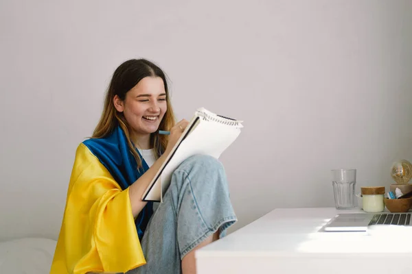 Ukraynalı Bir Genç Kız Ukrayna Bayrağına Sarılmış Yatak Odasında Ödev — Stok fotoğraf
