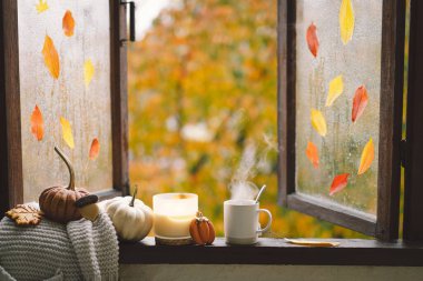 Güzel evim. Evdeki ahşap penceredeki hayat ayrıntıları. Süveter, mum, sıcak çay ve sonbahar dekoru. Sonbahar evi dekorasyonu. Samimi düşüş havası. Şükran Günü. Cadılar Bayramı. Sıcak sonbahar ya da kış konsepti.
