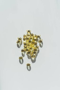 Beyaz arka planda vitaminler. Kaşık üzerindeki kapsüller: balık yağı, omega 3, omega 6, omega 9, A vitamini, D vitamini, D3 vitamini, E vitamini konsepti.