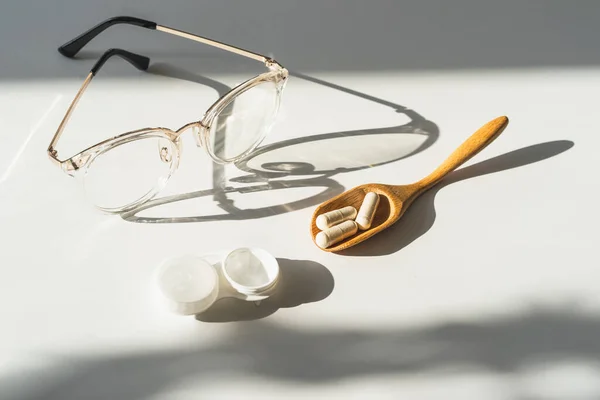 Treating vision problems. Ophthalmologist accessories for improving vision, tablets and vitamins, contact lenses, glasses. Eye and vision treatment concept
