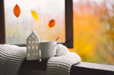 Güzel evim. Evdeki ahşap penceredeki hayat ayrıntıları. Süveter, sıcak çay ve sonbahar dekoru. Sonbahar evi dekorasyonu. Samimi düşüş havası. Şükran Günü. Cadılar Bayramı. Sıcak sonbahar ya da kış konsepti.