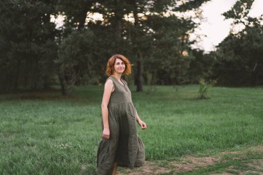 Güzel hamile bir kadın dışarıda, mutlu bir bebek bekliyor ve mutlu bir hamilelik dönemi geçiriyor. Hamilelik ve aile kavramları. Annelik. Hamile karnı. Bebek bekliyor.