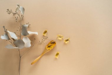 Beyaz arka planda vitaminler. Kaşık üzerindeki kapsüller: balık yağı, omega 3, omega 6, omega 9, A vitamini, D vitamini, D3 vitamini, E vitamini konsepti.