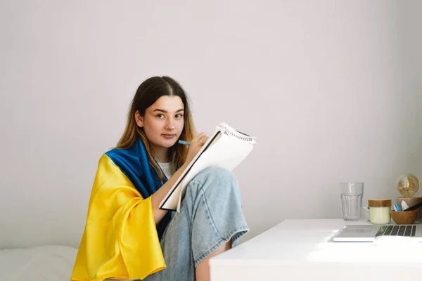 Ukraynalı Bir Genç Kız Ukrayna Bayrağına Sarılmış Yatak Odasında Ödev — Stok fotoğraf