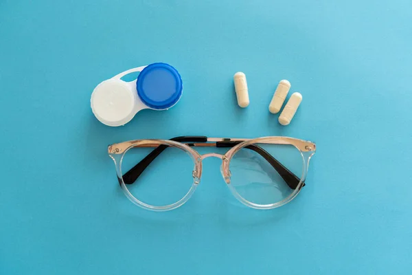 Treating vision problems. Ophthalmologist accessories for improving vision, tablets and vitamins, contact lenses, glasses. Eye and vision treatment concept