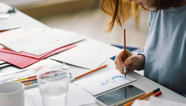 Genç kız, Kardan Adam 'la renkli kâğıt başvurusu yapıyor. Yaratıcılık kavramı. Kız el işi, kartpostal, kağıt, yaratıcılık için çok renkli kağıtlar yapıyor. Evden çalışıyorum. Hobi