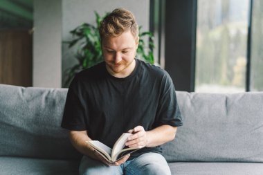 Hristiyan adam kutsal İncil 'i elinde tutuyor. Bir evde İncil 'i okumak. İnanç, maneviyat ve din kavramı. Barış, umut
