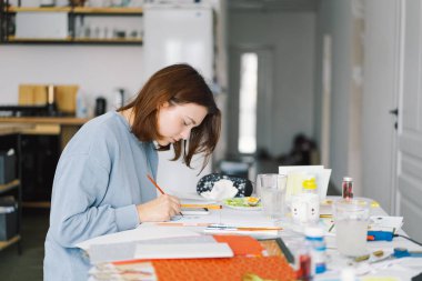 Genç kız, Kardan Adam 'la renkli kâğıt başvurusu yapıyor. Yaratıcılık kavramı. Kız el işi, kartpostal, kağıt, yaratıcılık için çok renkli kağıtlar yapıyor. Evden çalışıyorum. Hobi
