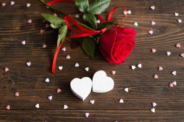 Red rose with postcard on wooden background. Happy Valentines Day postcard. Love concept for mothers day or valentines day. Valentine card with space for text