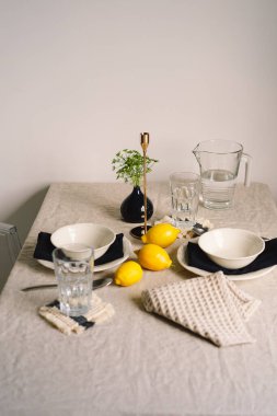 Vintage table setting with Linen napkins and yellow lemons. Decoration table. Close up. Cozy calm meal in the morning in the sunshine.
