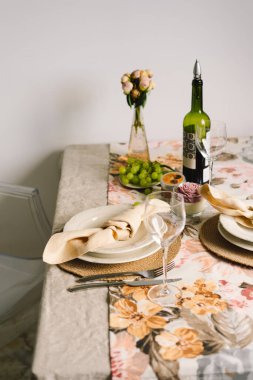 Vintage table setting with Linen napkins and floral decorations. Close up. Cozy calm meal in the morning in the sunshine.