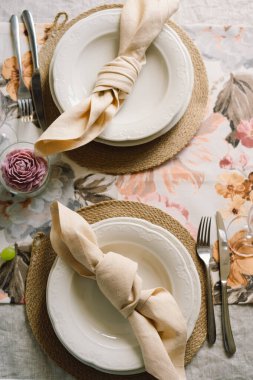 Vintage table setting with Linen napkins and floral decorations. Close up. Cozy calm meal in the morning in the sunshine.