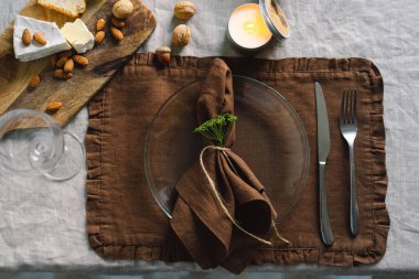 Vintage table setting with Linen napkins and floral decorations. Close up. Cozy calm meal in the morning in the sunshine.