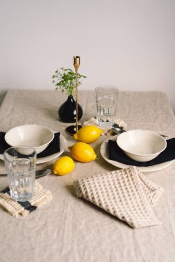 Vintage table setting with Linen napkins and yellow lemons. Decoration table. Close up. Cozy calm meal in the morning in the sunshine.