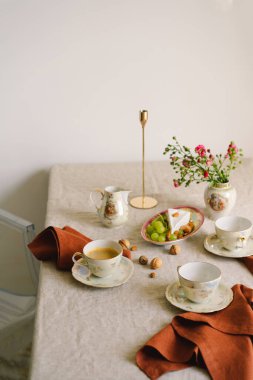 Vintage table setting with Linen napkins and floral decorations. Close up. Cozy calm meal in the morning in the sunshine.