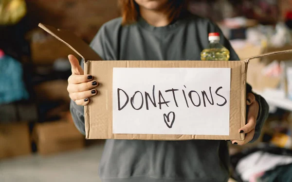 stock image Volunteer teengirl preparing donation boxes for people. Donation clothing for refugees, support of war victims. Humanitarian aid concept.Helping people