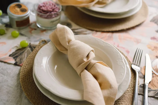 Vintage table setting with Linen napkins and floral decorations. Close up. Cozy calm meal in the morning in the sunshine.