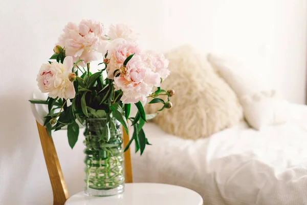 リビングルームの白い椅子にピンクの牡丹の花束 母の日 愛とロマンチックな概念 — ストック写真