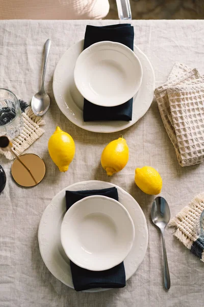 Vintage table setting with Linen napkins and yellow lemons. Decoration table. Close up. Cozy calm meal in the morning in the sunshine.