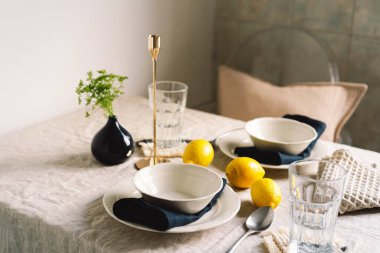 Vintage table setting with Linen napkins and yellow lemons. Decoration table. Close up. Cozy calm meal in the morning in the sunshine.
