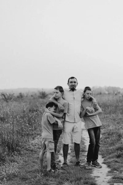 stock image Happy Fathers day. Father with son are walking in the field. Dad hugs boy. The concept of Fathers day, relationships with children, care and love.