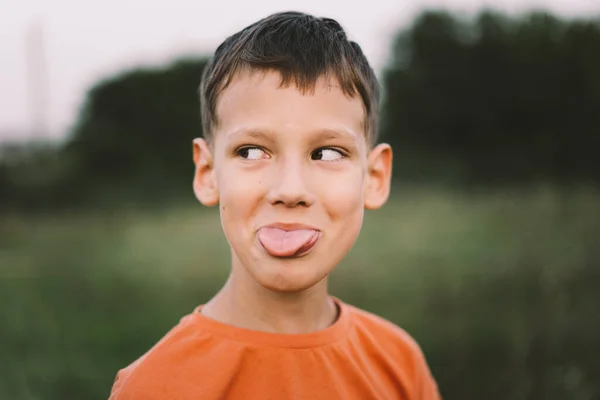 Portret Zabawnego Chłopca Pomarańczowej Koszulce Bawiącego Się Dworze Zachodzie Słońca — Zdjęcie stockowe