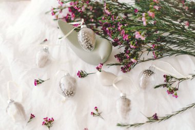 Beyaz çarşaf kumaşında çiçekler olan Paskalya yumurtaları. Bahar ve Paskalya konsepti.