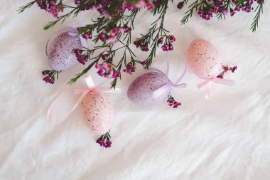 Beyaz çarşaf kumaşında çiçekler olan Paskalya yumurtaları. Bahar ve Paskalya konsepti.