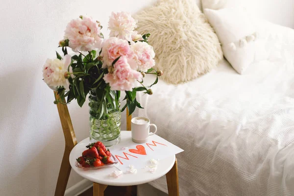 母の日の朝食 新鮮なイチゴとハート型の白いプレート コーヒーカップ ギフト ベッドの贈り物と牡丹の花束 まだ人生の構成 母の日 — ストック写真