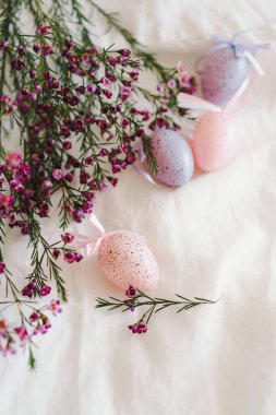 Beyaz çarşaf kumaşında çiçekler olan Paskalya yumurtaları. Bahar ve Paskalya konsepti.
