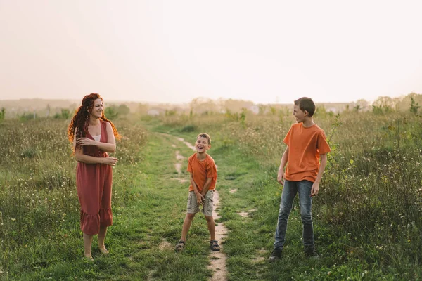 Mutlu anne dışarıda iki oğluyla eğleniyor. Aile ve sevgi kavramı. Anneler Günü kavramı, gençlerle ilişki, ilgi ve sevgi..