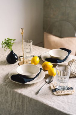 Vintage table setting with Linen napkins and yellow lemons. Decoration table. Close up. Cozy calm meal in the morning in the sunshine.