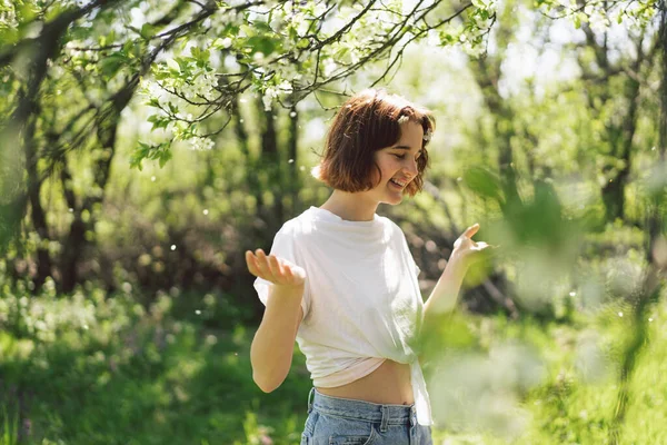 아름다운 소녀가 꽃으로 자연을 즐기고 정원에서 웃음을 가지를 자유와 행복의 — 스톡 사진